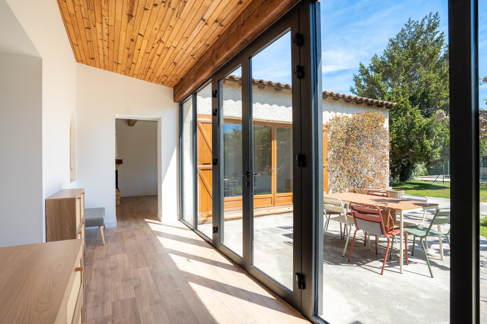 Véranda créée par la pose d'une nouvelle menuiserie, ouverte sur la terrasse – Istres